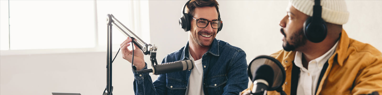 Happy radio presenter interviewing a podcast guest in a studio